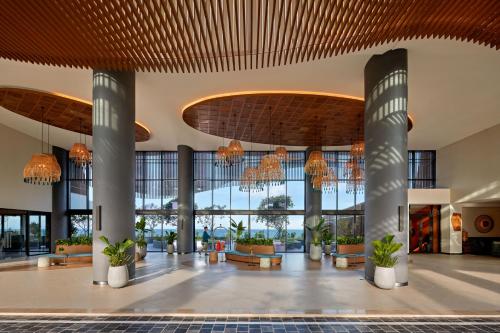 a lobby with large windows and chandeliers at Angsana Quan Lan, Ha Long Bay in Quan Lạn