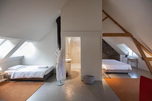 a bedroom with two beds and an attic at Château du Pont d'Oye in Habay-la-Neuve