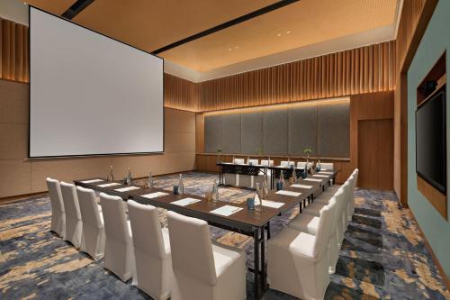 a conference room with a long table and white chairs at Angsana Quan Lan, Ha Long Bay in Quan Lạn