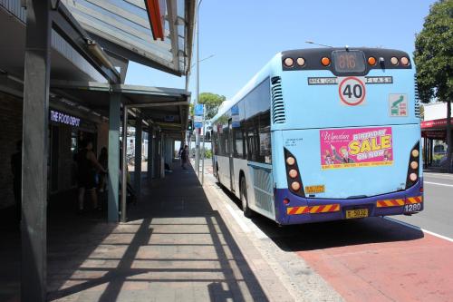 a bus is parked at a bus stop at Alison's central apartment in Cabramatta