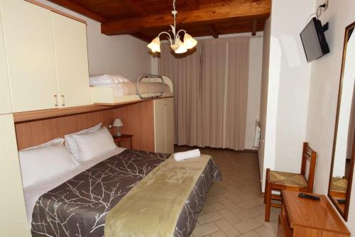 a bedroom with a bed and a table and a desk at CASA MAIRA IN CENTRO A SATURNIA in Saturnia