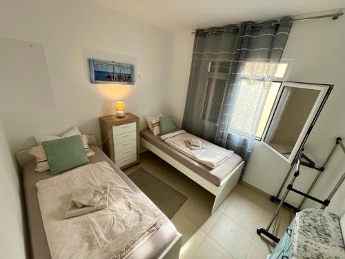 a small bedroom with two beds and a window at Villa SCIROCCO Madeira - Ocean View in Machico