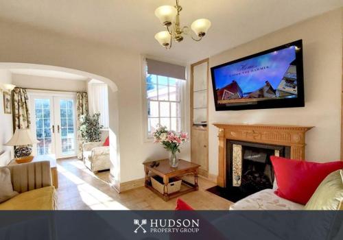 a living room with a fireplace and a flat screen tv at Town Centre Period Property by Shrewsbury Abbey in Shrewsbury