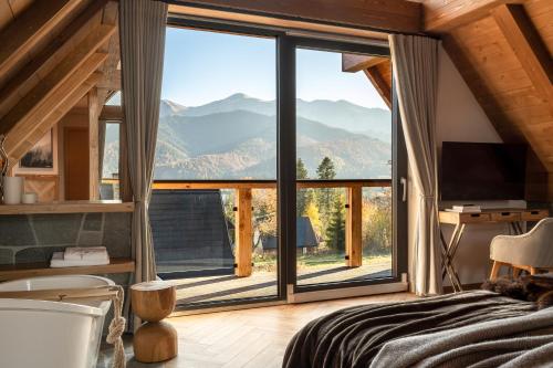 a bedroom with a large window with a mountain view at Villa La Roca Garden and Spa in Kościelisko