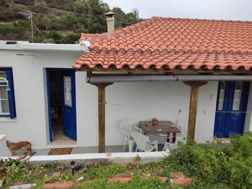 a white house with a table and chairs on a patio at Traditional house near the sea in Platána