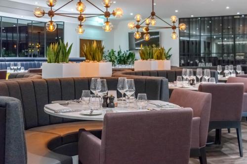 a restaurant with tables and chairs and chandeliers at Garner Hotel Preston Samlesbury by IHG in Preston