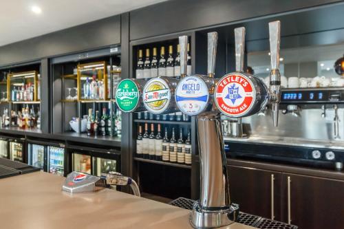 a bar with a bunch of stickers on a pole at Garner Hotel Preston Samlesbury by IHG in Preston