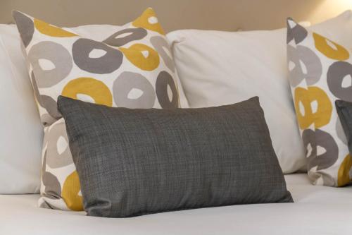 a bunch of pillows sitting on a bed with a cushion at Garner Hotel Preston Samlesbury by IHG in Preston