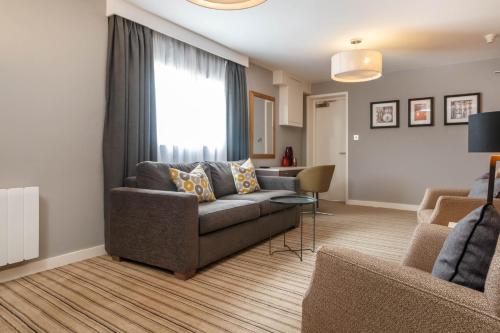 a living room with a couch and a window at Garner Hotel Preston Samlesbury by IHG in Preston