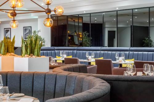 a restaurant with tables and chairs and lights at Garner Hotel Preston Samlesbury by IHG in Preston