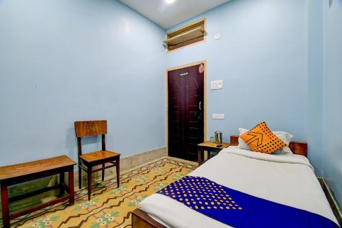 a bedroom with a bed and a table and a door at Hotel O Gajraj in Guwahati