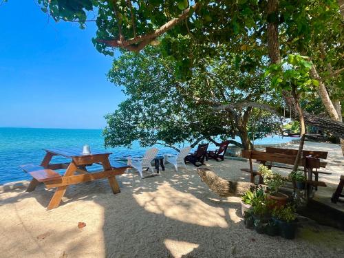 a picnic table and chairs on the beach at Baanbua bungalows Koh Chang Ranong in Koh Chang Ranong