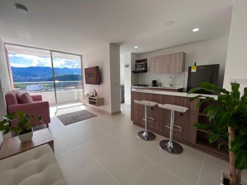a large living room with a kitchen and a living room at Hermoso apto en poblado con piscina in Medellín