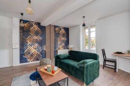 un salon avec un canapé vert et une table dans l'établissement Cocon de la Place, à Villefranche-de-Lauragais