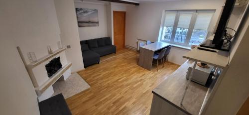 een woonkamer met een bank en een tafel bij Cosy Park Apartment, Free parking, Self-Check-In in Klaipėda