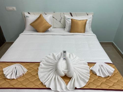 ティルパティにあるAthidi Luxury Home Stay - AC 2BHK Fully Furnished Flat with TV, WI-FI, 24Hrs Hot water, Parking, Elevator, Power Backupの大きな白いベッド(タオル付)