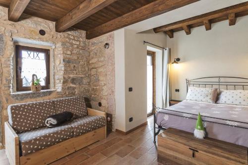 a bedroom with a bed and a couch in a room at Malga Laben Apartments in Velo Veronese