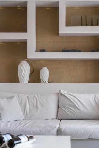 a living room with a white couch and mirrors at Kymothoe Elite Suites in Tsilivi
