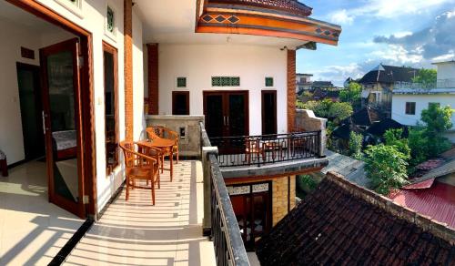 a balcony of a house with a table and chairs at Arya homestay in Ubud