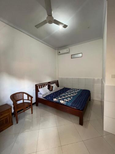 a bedroom with a bed and a ceiling fan at Arya homestay in Ubud