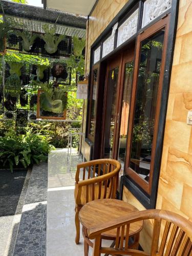 a wooden chair and a table on a patio at Arya homestay in Ubud