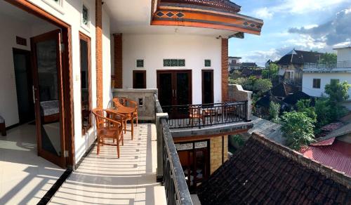 a balcony of a house with a table and chairs at Arya homestay in Ubud