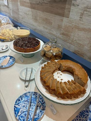 un tavolo con sopra diverse torte e piatti di Brisa do Mar Barê Praia Hotel - Praia de BAREQUEÇABA a São Sebastião