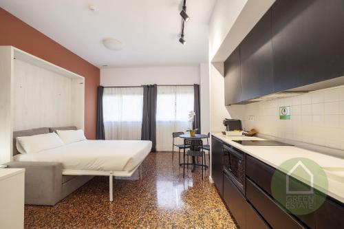 Una habitación de hotel con una cama y una cocina. en Apartahotel Espai Verd Benimaclet, en Valencia