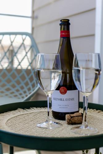 a bottle of wine and two glasses on a table at Coastal Dreams (#1) in Dromana