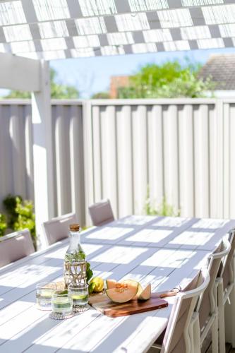 a table with a plate of food and a bottle at Coastal Dreams (#1) in Dromana