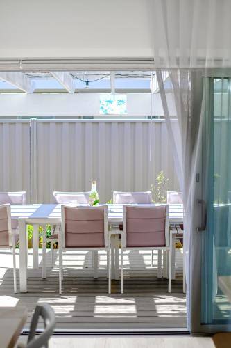 a white dining table and chairs on a patio at Coastal Dreams (#1) in Dromana