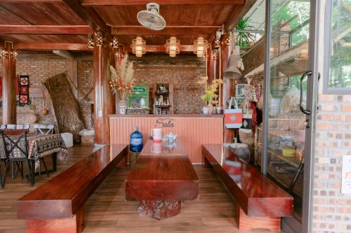 a restaurant with wooden benches in a room at Pù Luông Sala Homestay in Hương Bá Thước