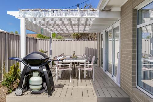 a patio with a table and a scooter on a deck at Coastal Dreams (#1) in Dromana