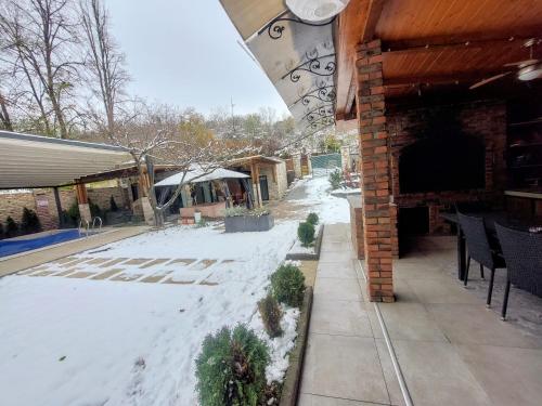 a patio with snow on the ground next to a building at Vila MP Banstol 4*- Brdež do, Fruška gora in Inđija