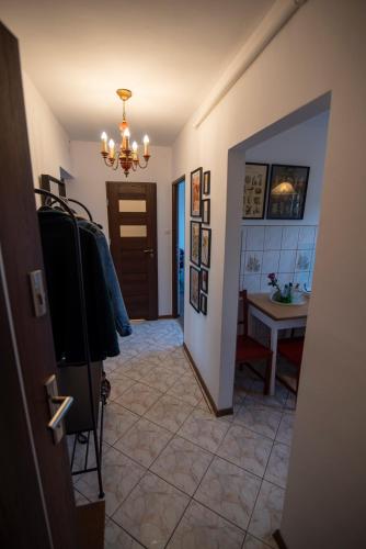 a hallway with a room with a table and a chandelier at Apartament Kama in Paczków