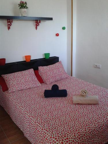 a bedroom with a bed with a red and white comforter at Apartamento Calle Goles in Seville