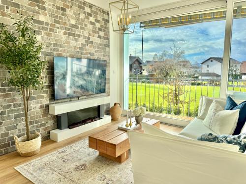 a living room with a fireplace and a tv at FLAIR Apartments Vorarlberg - Stilvolles Wohnen nahe Bodensee & Alpen - Küche, Balkon & Gratis Parkplatz in Bregenz
