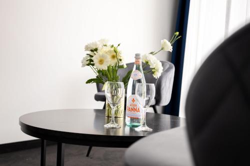 a bottle of wine and glasses on a table with flowers at Blue Star Luxury Hotel in Sofia