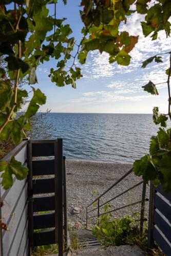 a stairway leading to a beach with the ocean at Ammoudeli Apartments in Plomarion