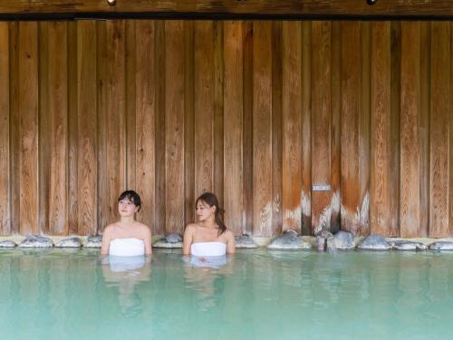 two women in the water in a swimming pool at Manza Prince Hotel in Tsumagoi
