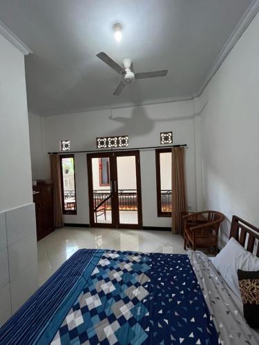 a bedroom with a bed and a ceiling fan at Arya homestay in Ubud