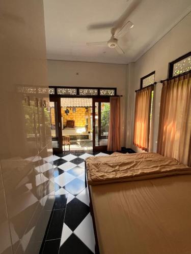 a bedroom with a bed and a black and white floor at Arya homestay in Ubud