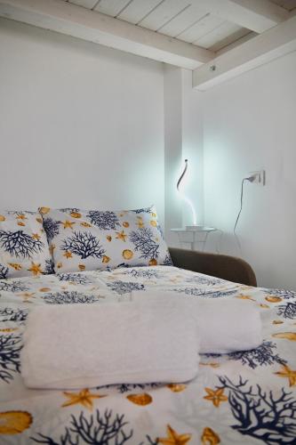 a bedroom with a bed with blue and white sheets at Mare Arcobaleno in Marzamemi