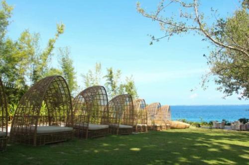 a row of bird cages sitting on the grass near the water at Budget friendly 1bedroom in The Mactan Newtown with pool&beach access in Punta Engaño