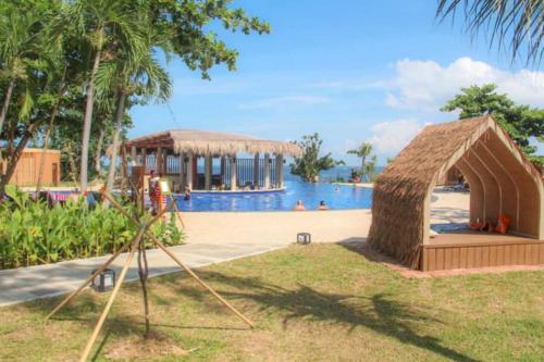 a resort with a large swimming pool with a igloo at Budget friendly 1bedroom in The Mactan Newtown with pool&beach access in Punta Engaño