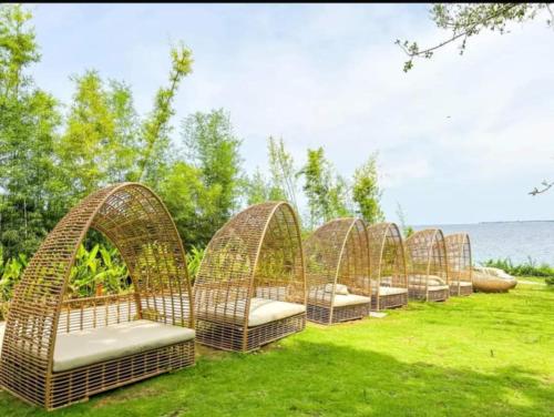 a row of wicker cots sitting in the grass at Budget friendly 1bedroom in The Mactan Newtown with pool&beach access in Punta Engaño