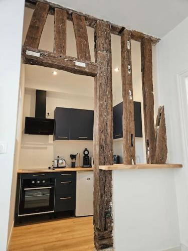 a kitchen with black and white appliances in a room at La Perle Bleue in Compiègne
