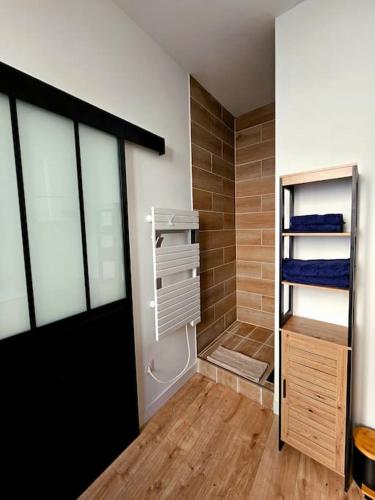 a bathroom with a walk in shower next to a walk in closet at La Perle Bleue in Compiègne