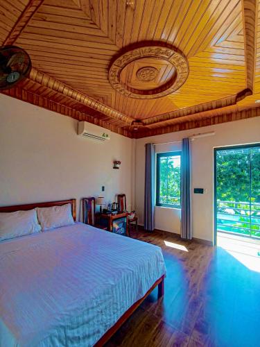 une chambre avec un lit avec un plafond en bois dans l'établissement YoLo Pool Bar Villas & Garden Restaurant, à Phong Nha