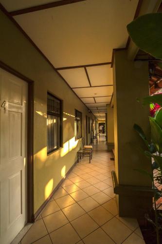 a hallway of a building with a door and a room at Hotel Iguana Verde in Orotina